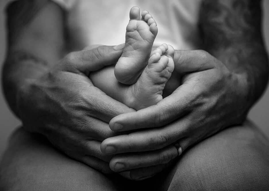 Hands holding tiny babies feet