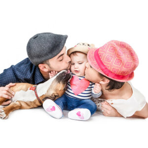 Mum, Dad, Baby and family dog all snuggling in a picture
