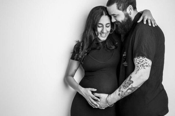 Man cradling his wife's pregnant belly
