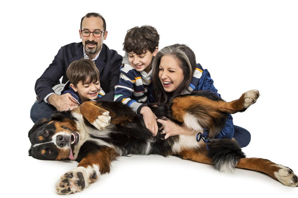 Family cuddling up to their dog