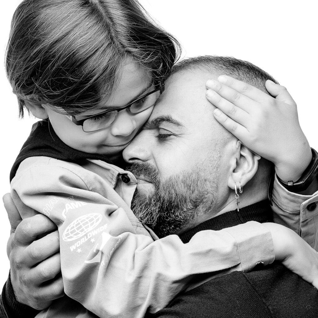 a black and white image of a father and son embracing