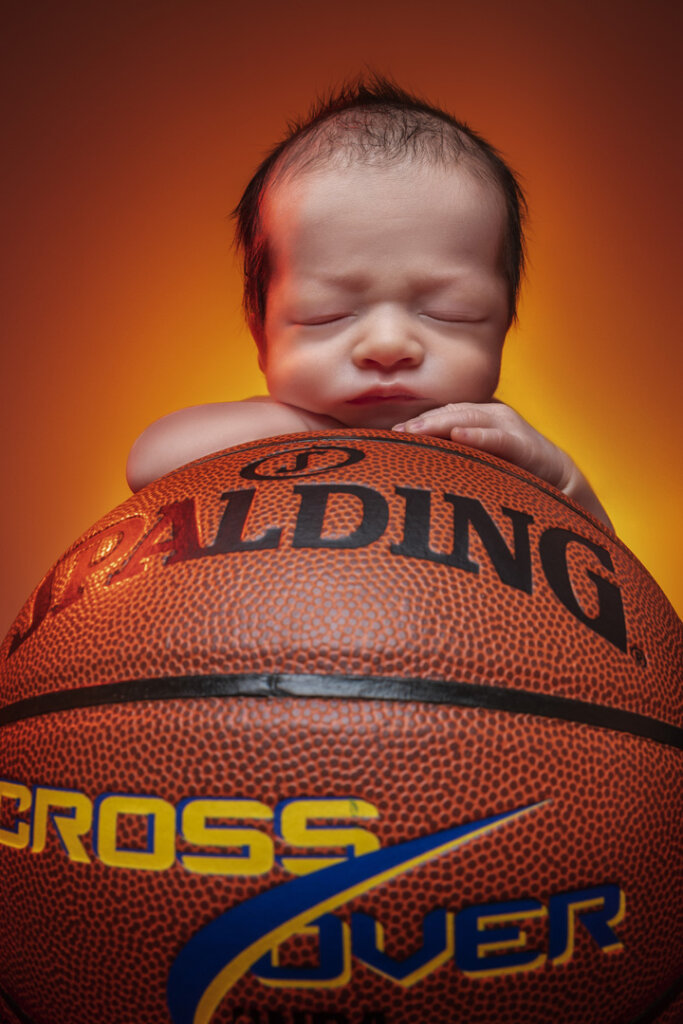 Baby laying on a basketball