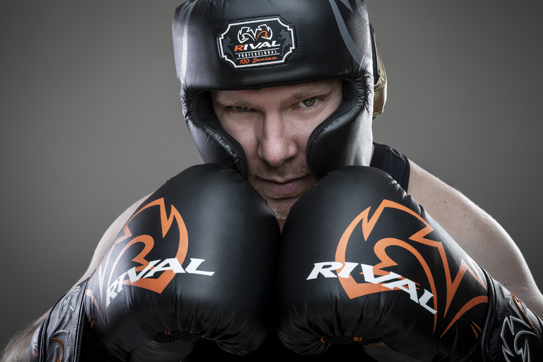 A portrait of a man wearing boxing gloves and helmet
