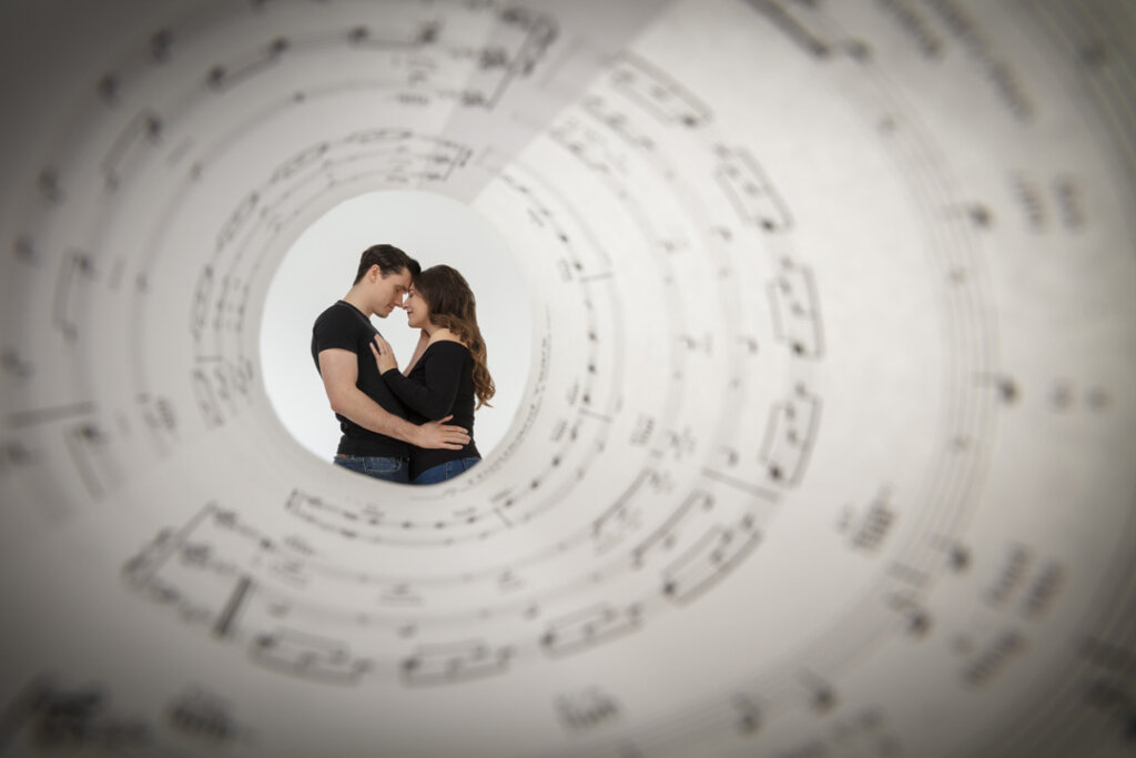 A couple photographed through a funnel of music notes