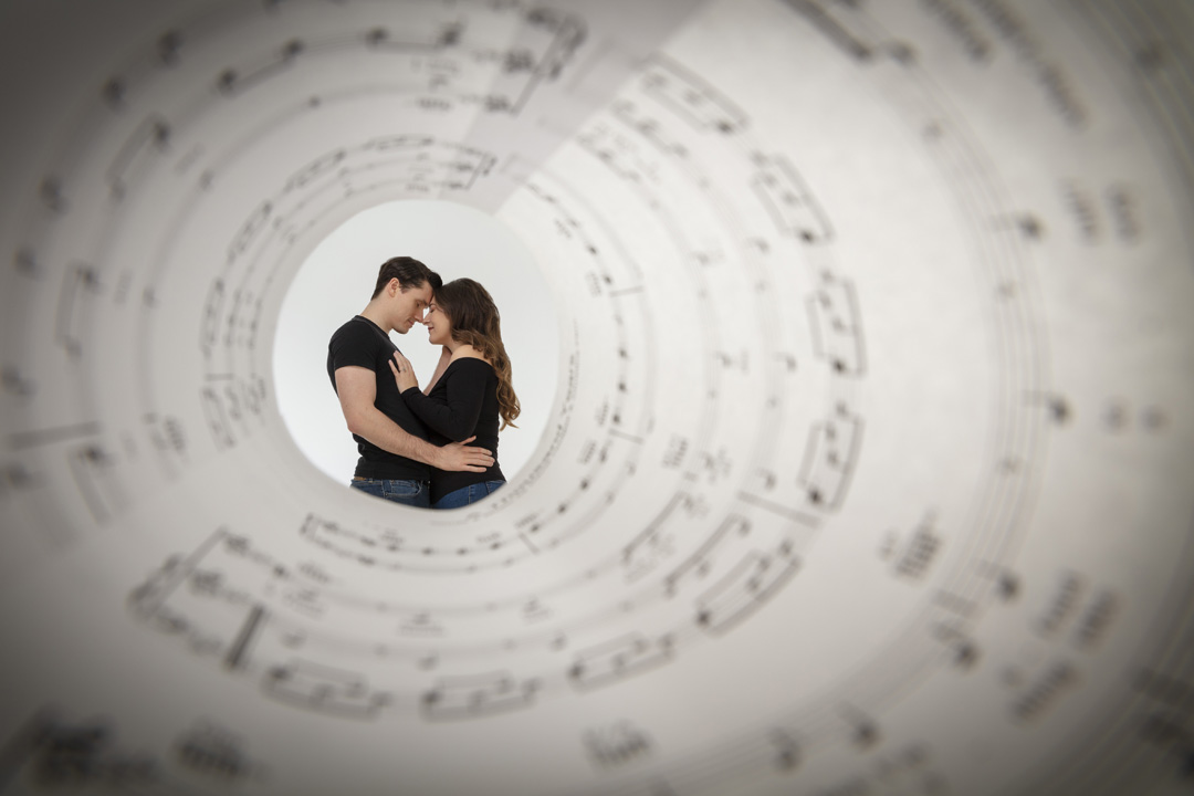 A couple photographed through a funnel of music notes