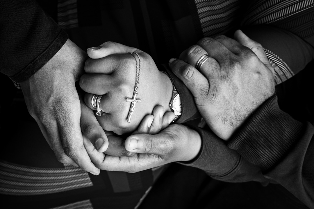 A close up of a family holding hands