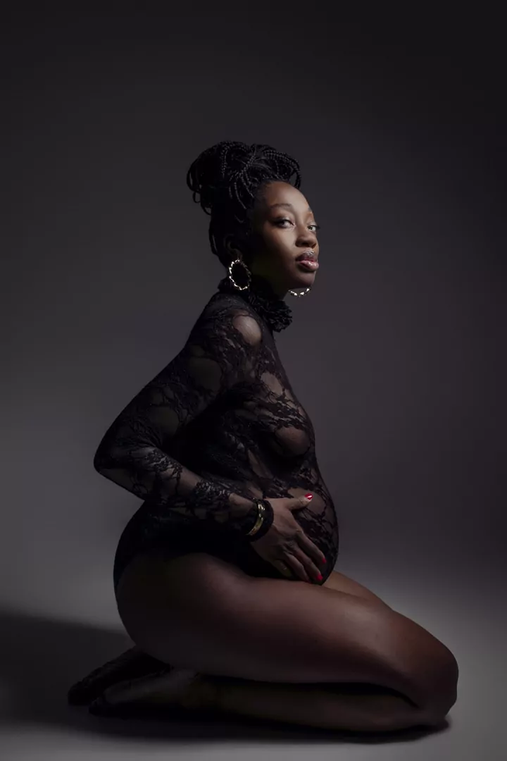 A pregnant woman on a dark background